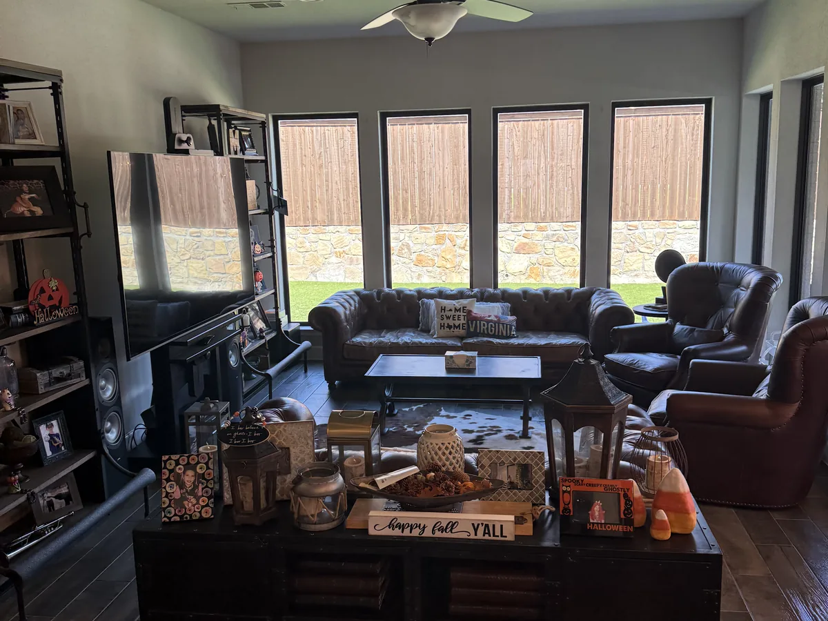 Tidy living room with leather sofas and fall decor after a house cleaning in Little Elm, Texas