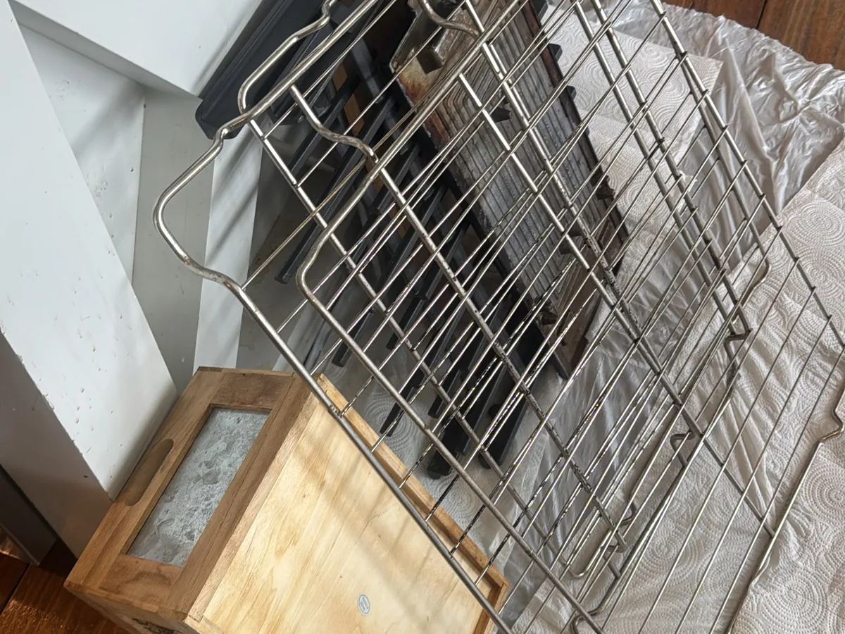 Scrubbed wire oven racks set out to dry on a wood counter after cleaning