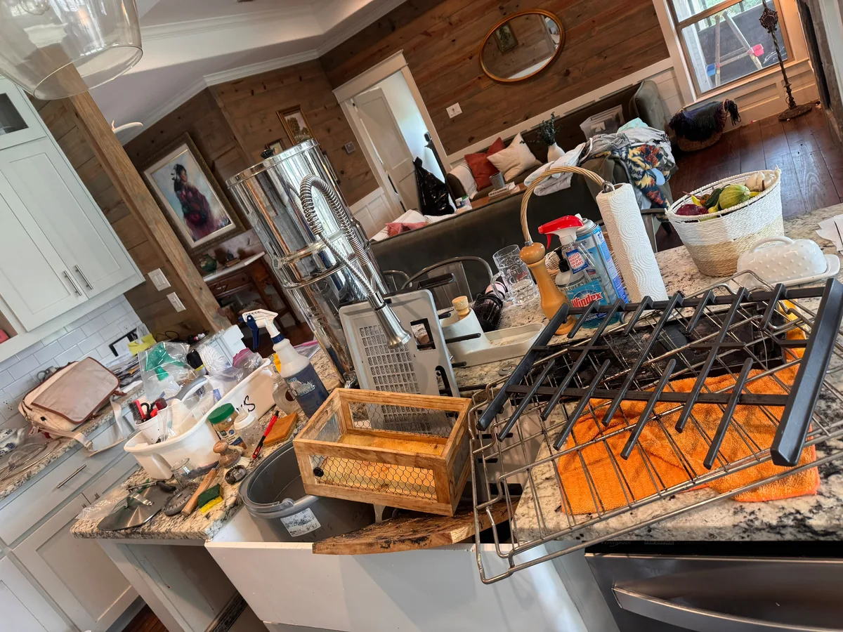 Kitchen counters covered in small appliances and removed stove grates